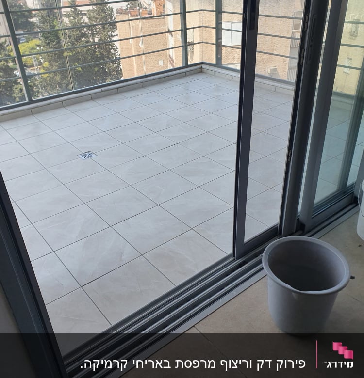 מרפסת מרוצפת עם דלי וכבל כחול